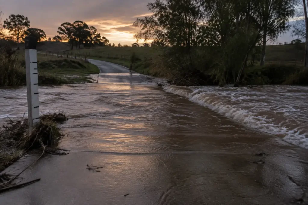 Illustration: floodwater running over a low-water road crossing.