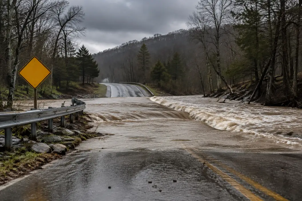 Illustration: floodwater running over a low water crossing beside a warning sign