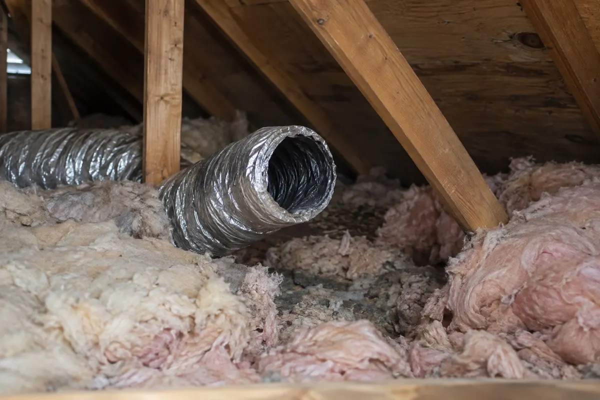Illustration: a bathroom extract duct terminating loose in an attic instead of connecting to a roof vent.