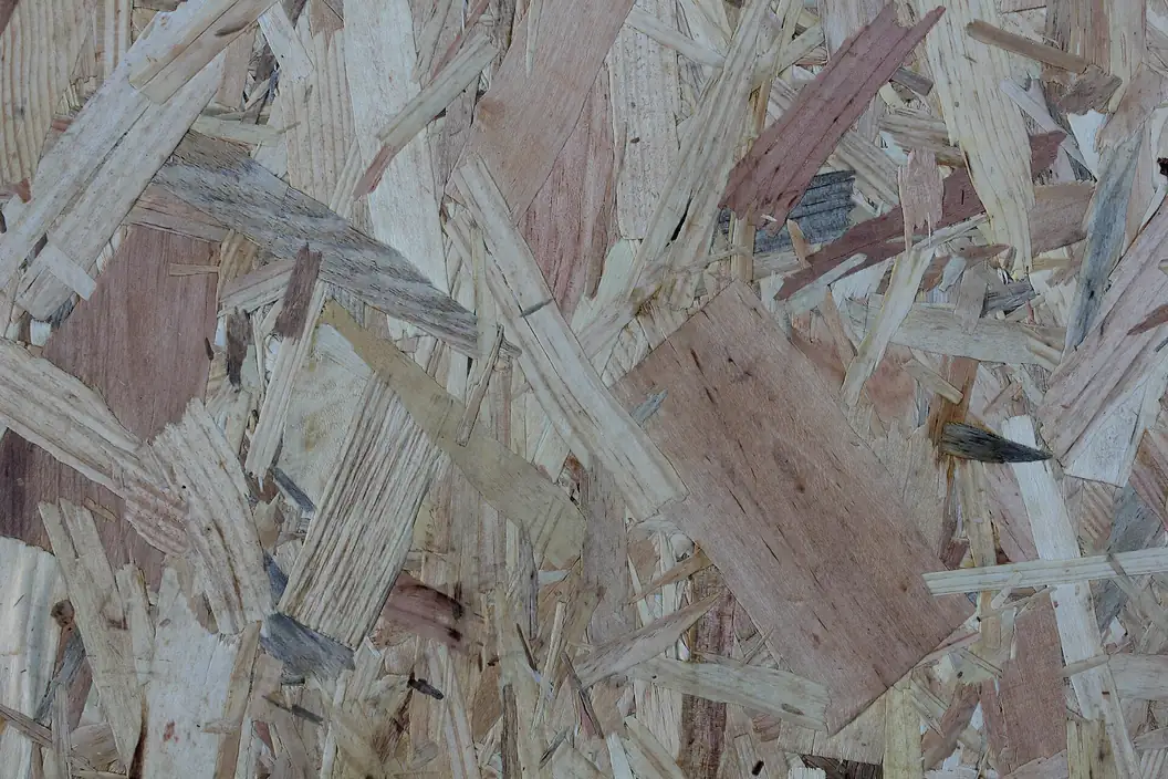 Close-up of an oriented strand board surface showing large flat wood strands laid in overlapping directions