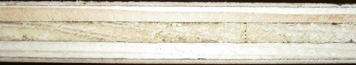 Edge of a plywood sheet showing distinct thin veneer layers glued together